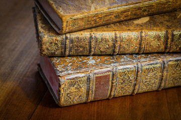 Wall Mural - Pile of antique books with a leather cover and golden ornaments on a wooden table