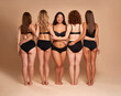 © gpointstudio - Rear and full length view of women in black underwear standing on nude background