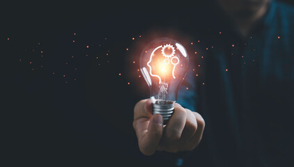 businessman holding glowing lightbulb and human icon thinking with copy space for creative thinking 