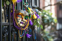 New Orleans Mardi Gras Mask With Bead Necklaces Hanging On Wrought Iron Fence In The Day Created With Generative AI Technology