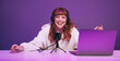 © Jacob Lund - Happy young woman laughing while recording a live radio show in a studio