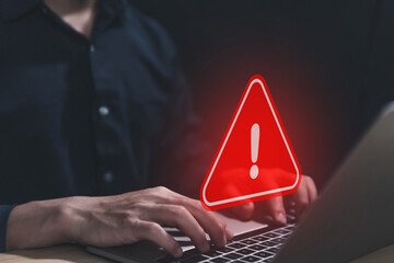 Wall Mural - businessman using laptop showing warning triangle and exclamation sign icon caution of dangerous pro