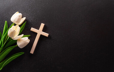 good friday and holy week concept - a religious cross and flower on dark stone background.