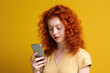 © ADDICTIVE STOCK - Red-haired woman looking at her mobile. Generative AI