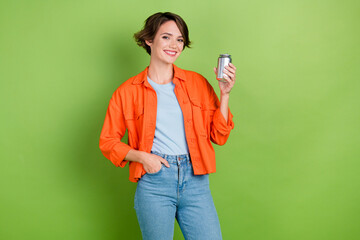 Poster - Photo of cheerful positive lady dressed jeans shirt rising lemonade can empty space isolated green color background