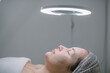 © Anna - Young woman on a cosmetology facial skin care procedure in a beauty salon. Cosmetologist and dermatologist performs a facial procedure