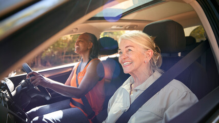 Wall Mural - Two Senior Female Friends Enjoying Day Trip Out Driving In Car Together