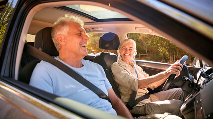 Wall Mural - Senior Couple Enjoying Summer Day Trip Out Driving In Car Together