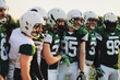 © Flamingo Images - Smiling American football team standing on sports field