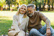 © LIGHTFIELD STUDIOS - portrait of charming middle aged couple sitting together in green park during springtime.