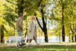 © LIGHTFIELD STUDIOS - happy middle aged woman in casual attire walking out with husband and labrador dog in green park during springtime.