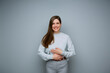 © Yuriy Shevtsov - Happy woman holding hands on stomach isolated portrait.
