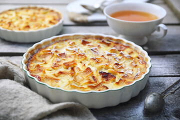 French cuisine. Apple flognarde (clafoutis), two portions and cup of tea