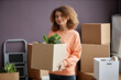 © Seventyfour - Portrait of young woman holding cardboard box with things and looking at camera