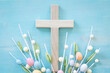 Cross and easter eggs on a blue wood background with copy space
