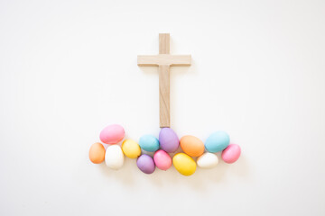 Wall Mural - Wood Christian cross with easter eggs on a white background with copy space