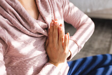 Midsection Of Caucasian Young Woman Meditating In Prayer Position While Sitting At Home