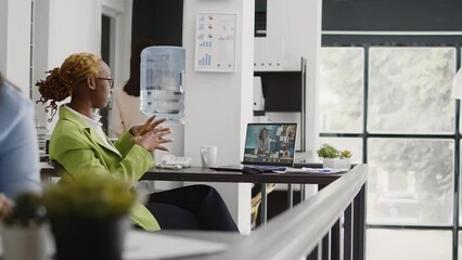 Canvas Print - Office worker using online remote conference on webcam, talking to business people about development. Female employee chatting on videoconference call, videocall meeting in office.