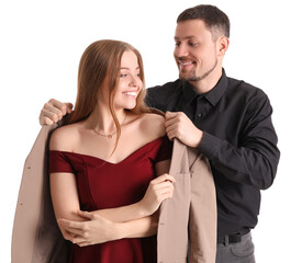 Canvas Print - Young man putting jacket onto his wife on white background