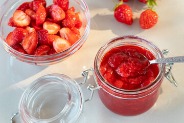 Wall Mural - Glass jar with strawberry jam prepared for canning and fresh strawberries in a bowl on the table