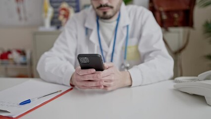 Poster - Young hispanic man doctor using smartphone working at clinic