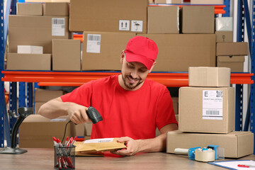 Poster - Post office worker with scanner reading parcel barcode at counter indoors