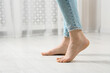 © New Africa - Woman stepping barefoot in room at home, closeup with space for text. Floor heating