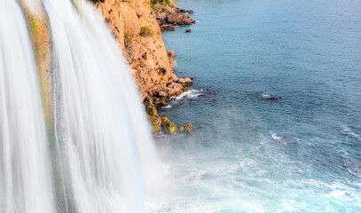 Wall Mural - Powerful Duden waterfall with rainbow, a water stream breaks from a high cliff - Antalya, Turkey