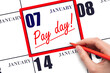 Hand writing text PAY DATE on calendar date January 7 and underline it. Payment due date