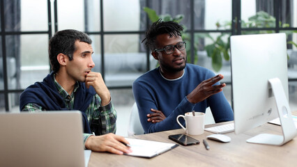 Business people working together in a modern trendy office behind a laptop