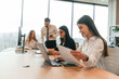 © standret - Sitting by the table. Business people in formal clothes are working in the office together