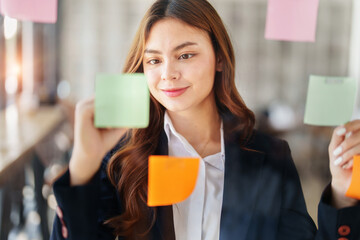 Beautiful young teen asian businesswoman using note pad thinking with planning working on financial document, tax, exchange, accounting and Financial advisor