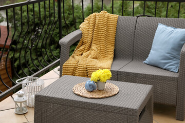 Canvas Print - Light blue pillow, soft blanket and yellow chrysanthemum flowers on rattan garden furniture outdoors