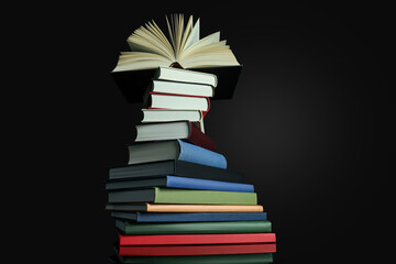 Stack of different hardcover books on black background