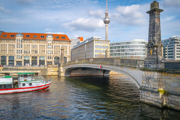Wall Mural - Monbijou Bridge, Berlin city skyline, buildings, and TV Tower over the Spree River with a river boat cruising under the bridge in the Capital of Germany