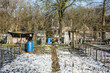 snow on the soil of the allotment garden with rain barrels on a sunny day