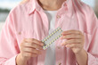 Woman holding blister of oral contraception pills, closeup