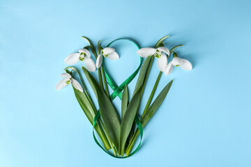 Wall Mural - Beautiful snowdrops and number 8 made of ribbon on light blue background, flat lay