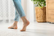 © New Africa - Woman stepping barefoot in room at home, closeup. Floor heating