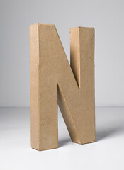 A 3d card letter N, alphabet and type card board cutout out. three dimensional letter shapes and moulds.