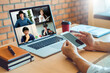 © joyfotoliakid - Asian man working from home use Smart working and video conference online meeting with Asian team using laptop and tablet online in video call for new projects