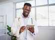 © Meeko Media - Portrait of a young Black doctor using digital tablet in bright office