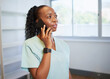 © Meeko Media - Young healthcare professional speaks on the phone wearing scrubs
