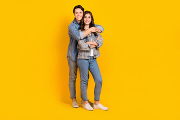 Wall Mural - Full length photo of cute adorable young husband wife dressed denim embracing smiling isolated yellow color background