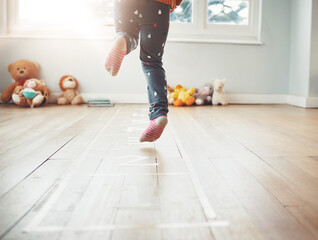 Poster - Hopscotch, happy and feet of child play in home having fun, enjoying games and entertainment in room. Childhood, kindergarten and excited girl in bedroom for jumping game, playing and floor activity