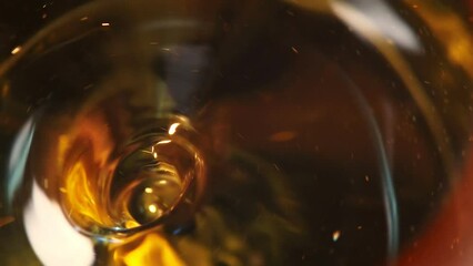 Poster - Abstraction of a slowly swirling whirlpool in amber liquid going into deep with a reflection on its surface with a lot of bubbles inside. Abstract motion design on a glowing background