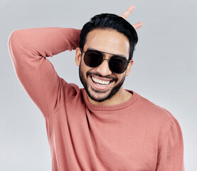 Wall Mural - Cool, funny and funky Asian man with sunglasses isolated on a white background in a studio. Portrait, comic and a laughing stylish Chinese guy with fashionable eyewear and crazy gesture on a backdrop