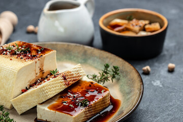 Wall Mural - marinated tofu with herbs and spices. vegetarian tofu cubes on a dark background. banner, menu, recipe place for text, top view