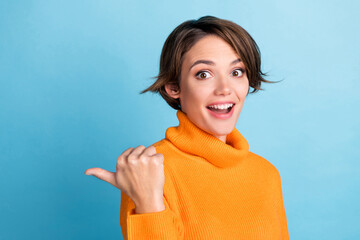 Canvas Print - Photo of astonished cheerful lady indicate thumb finger empty space isolated on blue color background