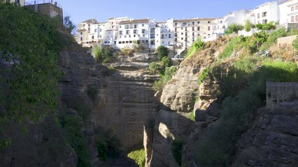 Wall Mural - Ronda, a beautiful view of Ronda’s El Tajo Canyon, houses and vegetation on a sunny summer day. Ronda, a famous UNESCO heritage city in Malaga Province, Andalusia, Spain